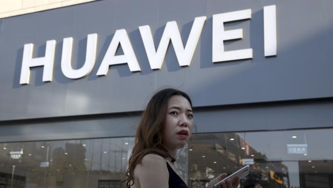 A woman uses a smartphone outside a Huawei store in Beijing Monday, May 20, 2019. Google is assuring users of Huawei smartphones the American company's services still will work on them following U.S. government restrictions on doing business with the Chinese tech giant. (AP Photo/Ng Han Guan)