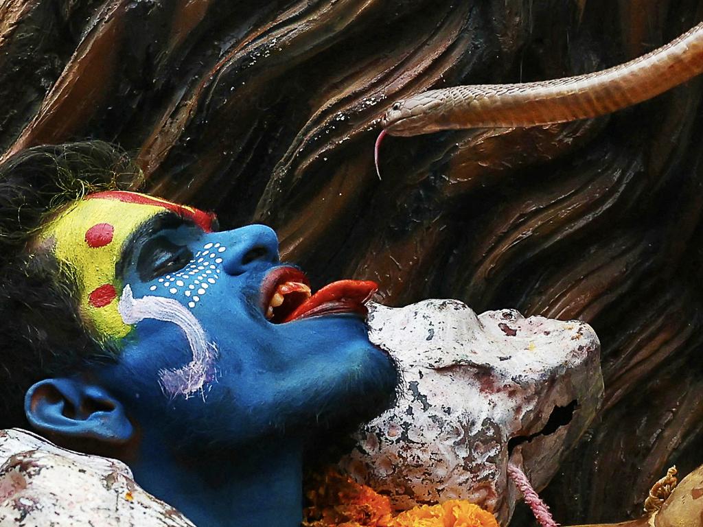 A Hindu devotee holds a snake next to his face during a religious procession during Holi, in Varanasi, India. Picture: Niharika Kulkarni/AFP