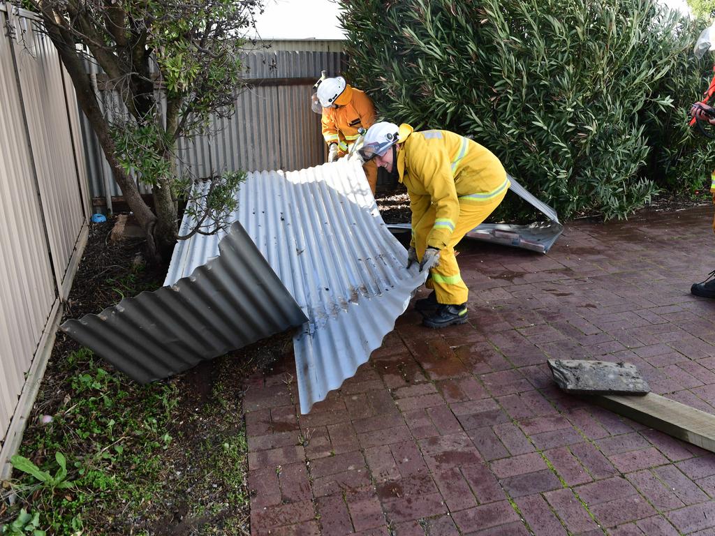 McLaren Vale CFS workers with roofing sheets that were blown across Commercial Rd at Port Noarlunga. Picture: Campbell Brodie