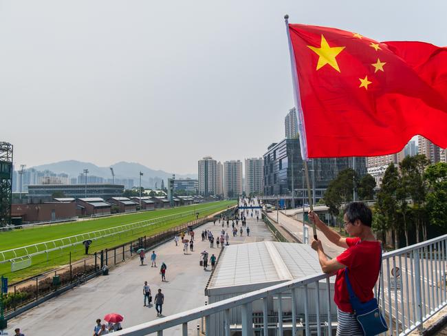 A man waves a China flag at the racecourse in Hong Kong during the National Day celebrations to mark the 70th anniversary of communist China's founding on October 1. Picture: Billy H.C. Kwok/Getty Images