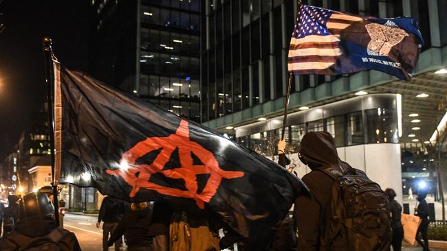 Members of Antifa walk with an Anarchy flag and a Black Lives Matter flag during a protest in Washington. Picture: Getty Images/AFP