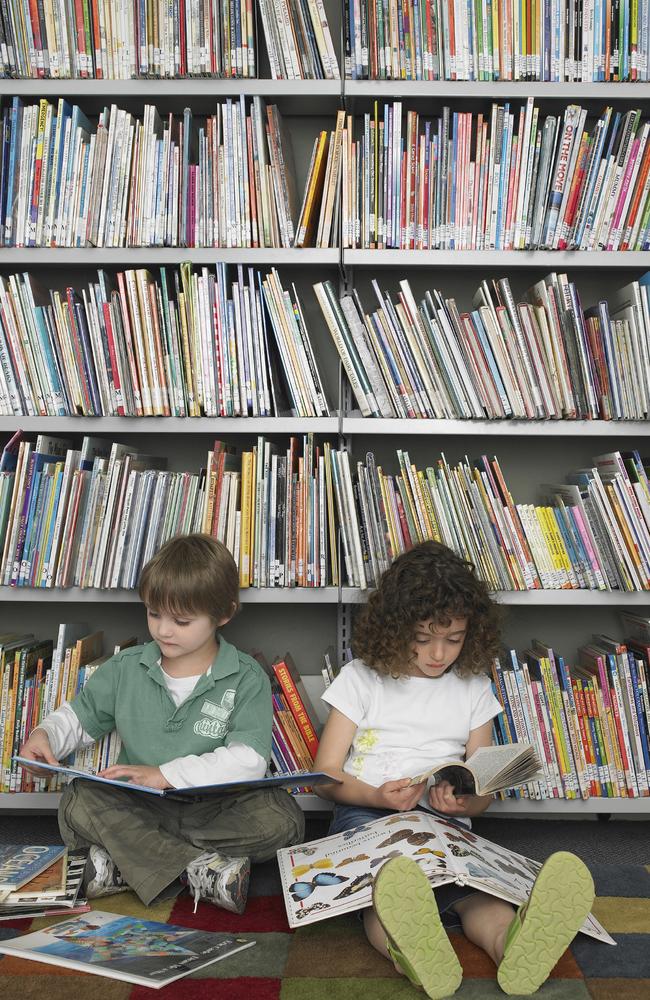 Kids absorbed in books at their local library.