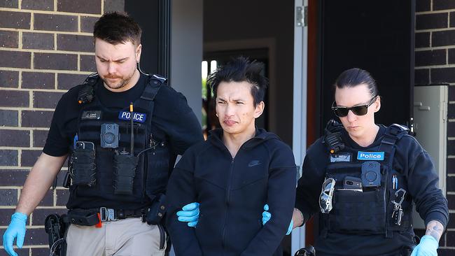 Police take a man into custody after a raid on a St Albans house who allegedly stole the identity of a woman to fund his family’s high-roller lifestyle. Picture: Ian Currie