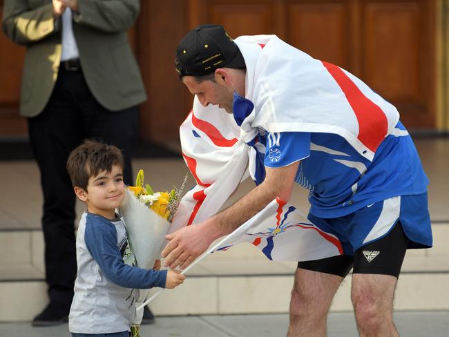 Victorian runner Isak Ketsakitis arrives at St Hurmizd's Cathedral (Assyrian Church of the East, Grrenfield Park, greeted by family and friends 30 July 2017. He has  run for over two days from Wollongong to Fairfield Assyrian Church to raise funds for charity.(AAP IMAGE/Simon Bullard)