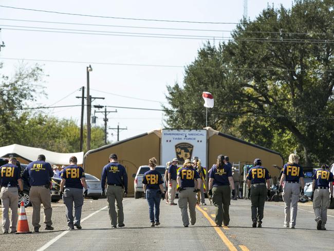 FBI agents search for evidence on a road near First Baptist Church in Sutherland Springs, Texas. Picture: Jay Janner/Austin American-Statesman via AP