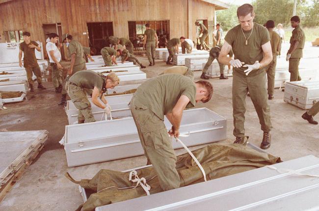 US military personnel place bodies in coffins at the airport in Georgetown, Guyana, after 900 members of the Peoples Temple committed suicide in Jonestown in November 1978.