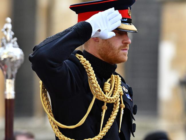 Prince Harry salutes after laying a Cross of Remembrance. Picture: AFP