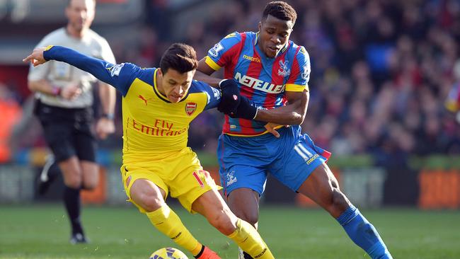 Arsenal's Chilean striker Alexis Sanchez (L) vies with Wilfried Zaha.