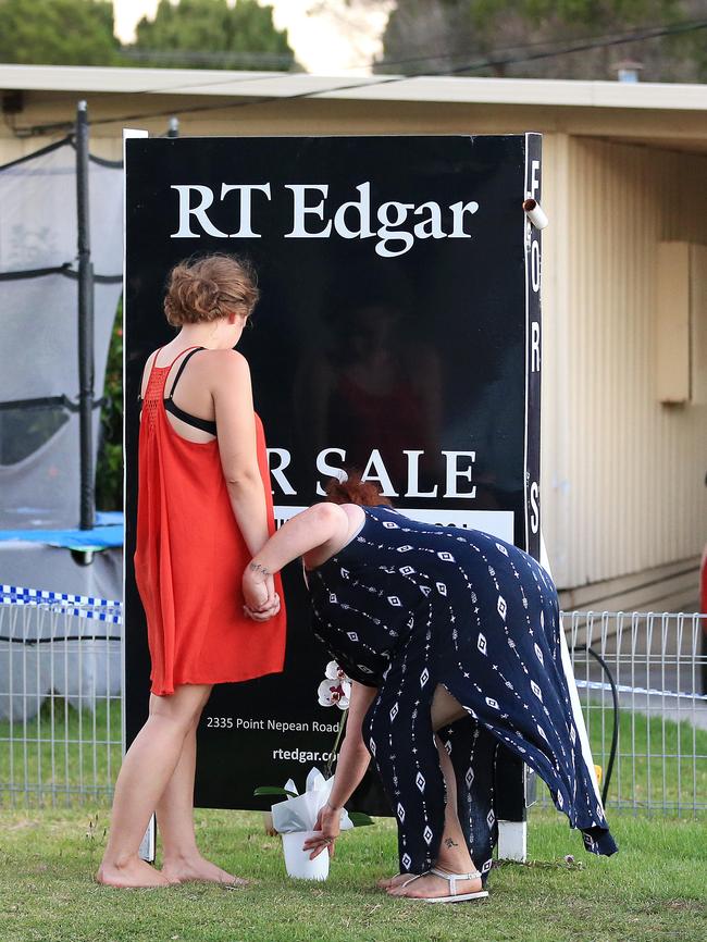 Two women pay their respects. Picture: Mark Stewart