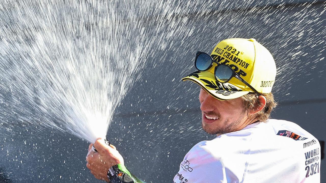 Australian rider Remy Gardner sprays prosecco, as he celebrates his Moto2 2021 World Champion title. (Photo by JOSE JORDAN / AFP)