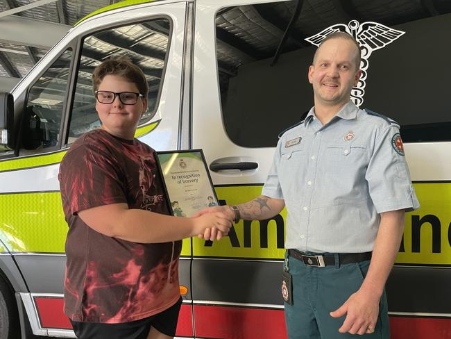 Michael Harwood, 12, congratulated by Emergency Medical Dispatcher Daniel Ryland after receiving an award for bravery. Picture: Leighton Smith.