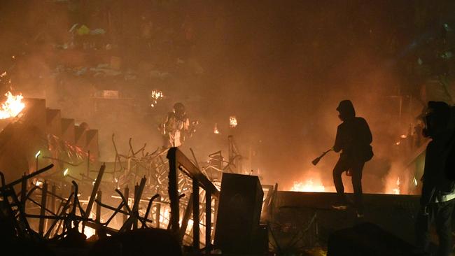 Anti-government protesters watch as a large fire is started at the Hong Kong Polytechnic University on Monday. Picture: Anthony Wallace/AFP