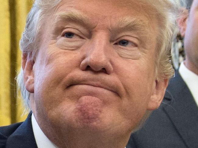 TOPSHOT - US President Donald Trump signs an executive order as Chief of Staff Reince Priebus looks on in the Oval Office of the White House in Washington, DC, January 23, 2017. Trump on Monday signed three orders on withdrawing the US from the Trans-Pacific Partnership trade deal, freezing the hiring of federal workers and hitting foreign NGOs that help with abortion. / AFP PHOTO / SAUL LOEB