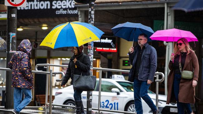 Be like these people on the streets of Adelaide and keep a brolly handy. Picture: Tom Huntley