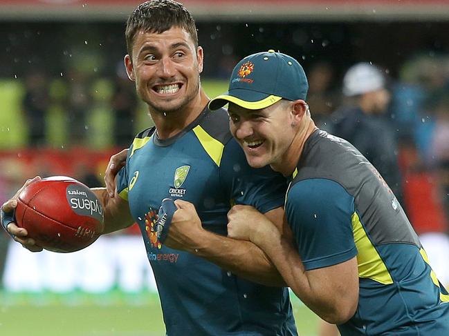 Marcus Stoinis and D`Arcy Short of Australia play with a football during a rain delay ahead of the International Twenty20 match between Australia and South Africa at Metricon Stadium. Picture: Getty Images