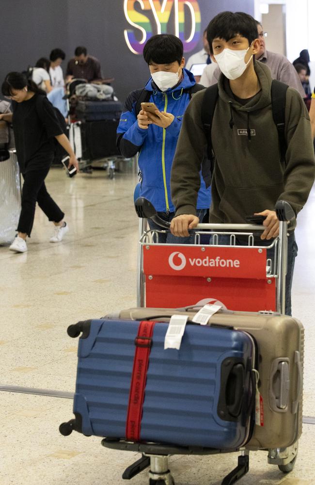 Coronavirus arrivals: Tourists arrive at Sydney International Airport wearing face masks. Picture: Brendan Read.