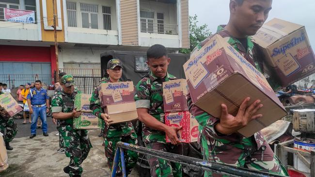 Indonesian military personnel load food items onto a ship as they head to the island near Mount Ruang volcano at the port in Manado, North Sulawesi, on April 18. Picture: AFP