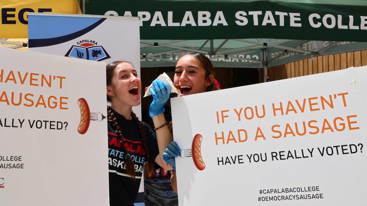 Grace, left, and Amber serving up some sausage wisdom at a Capalaba booth. Picture: NewsWire/Tertius Pickard