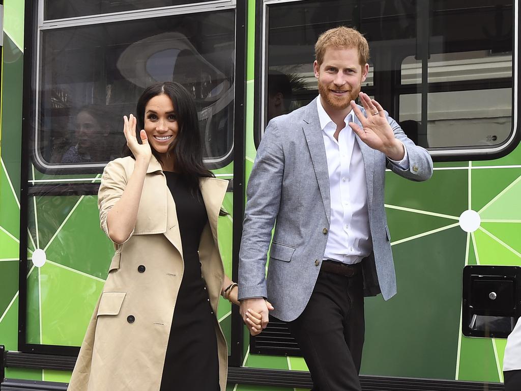 Britain's Prince Harry and his wife Meghan, Duchess of Sussex wave to the well-wishers after taking a ride on a tram in Melbourne, October 18, 2018. Picture: AAP