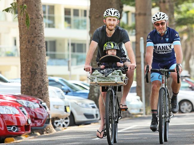 Dave Musgrove with son Bob, 13 months, and Jim Buda from the Manly Warringah Cycle Club say they think strict helmet laws will stop people cycling and force them into their cars instead. Picture: Troy Snook