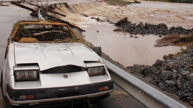 A car destroyed by floodwaters that inundated the John Muntz Causeway between Upper Coomera and Mount Tamborine on the Gold Coast. (AAP Image/Ed Jackson)