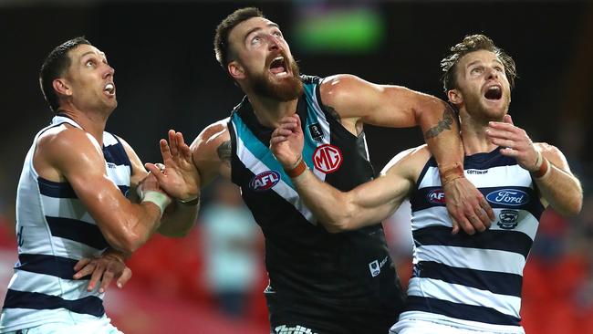 Charlie Dixon wrapped up by Geelong’s harry Taylor and Lachie Henderson.