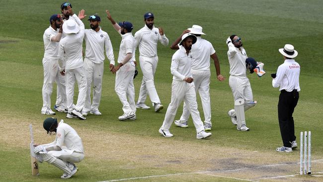 India’s players celebrate as Nathan Lyon soaks up defeat. Picture: AAP