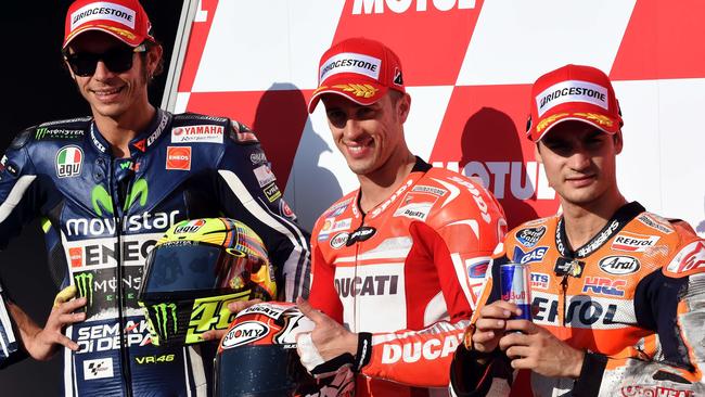 Ducati Team rider Andrea Dovizioso smiles with Movistar Yamaha MotoGP rider Valentino Rossi of Italy (L) and Repsol Honda Team rider Dani Pedrosa of Spain (R).