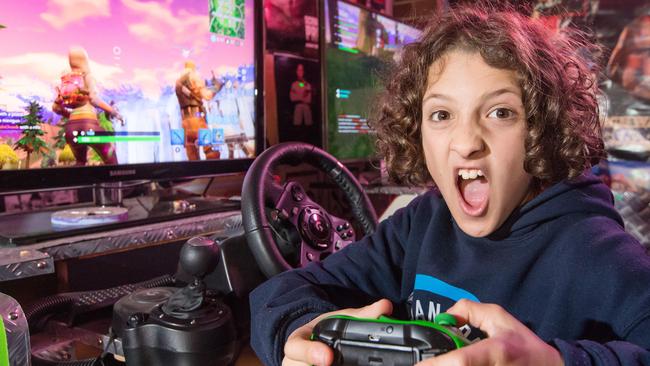 Luke Flower, 10, is playing Fortnite in his family's garage-turned arcade room. (Pic: Sarah Matray)