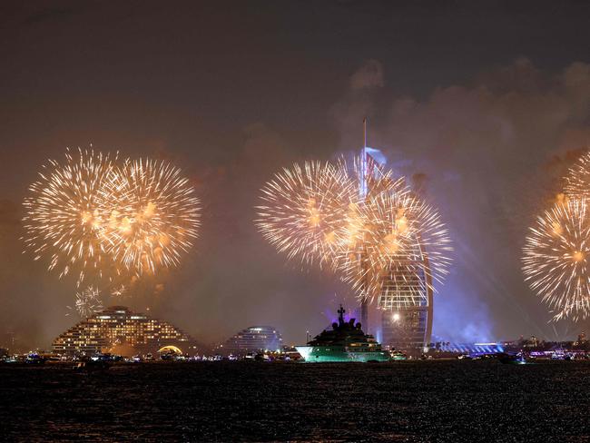 Fireworks light up the sky by the landmark Burj al-Arab luxury hotel tower in Dubai at midnight. Picture: AFP