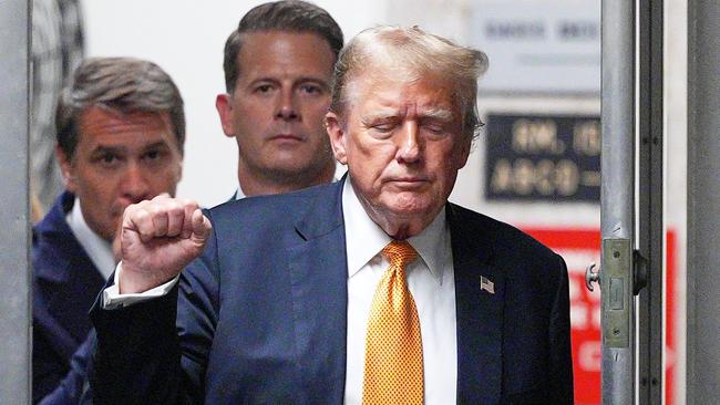 Donald Trump holds up a fist as he walks to the courtroom after the start of deliberations in his criminal trial at Manhattan Criminal Court. Picture: AFP.