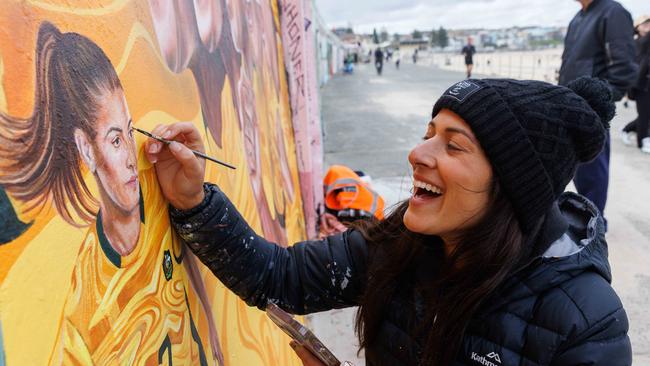 Ms Weber putting the finishing touches on her sea wall mural ahead of its official unveiling on Monday. Picture: NCA NewsWire / David Swift