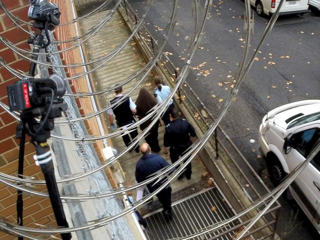 The SA woman is taken to the Adelaide Magistrates Court by security officers. Picture: Greg Higgs