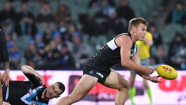 Ollie Wines of the Power hand balls during the Round 13 AFL match between the Port Adelaide Power and the Western Bulldogs at Adelaide Oval in Adelaide, Thursday, June 14, 2018. (AAP Image/David Mariuz) NO ARCHIVING, EDITORIAL USE ONLY