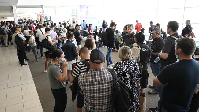 People are seen waiting for flights at Adelaide Airport after the new border restrictions came into place. Picture: NCA NewsWire / David Mariuz