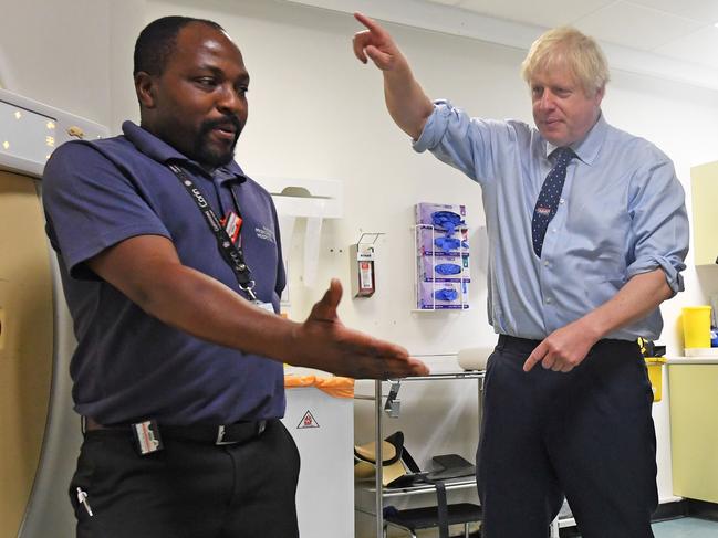 Where’s the exit? Britain's Prime Minister Boris Johnson talks with staff at a hospital in Harlow, north of London. Picture: AFP