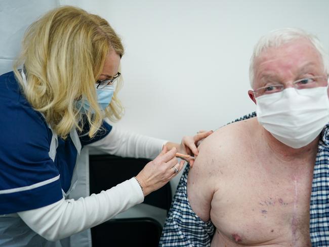 MIDDLESBROUGH, ENGLAND - JANUARY 28: Tom Richmond receives his AstraZeneca/Oxford University Covid-19 vaccine from Vaccinator Louise Chadwick at Acklam Road pharmacy on January 28, 2021 in Middlesbrough, England. The pharmacy is one of the first in the region to offer the Covid-19 vaccination. Members of the public who have received an NHS referral letter and who live in the Cleveland area can book a slot for a vaccination. The pharmacy vaccination centre has been commissioned to roll out 2,000 vaccinations a week, but it does have the capacity to distribute up to 10,000, should the NHS need it. (Photo by Ian Forsyth/Getty Images)