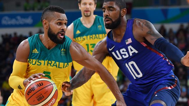 Patrick Mills, who is a star for the Boomers, takes on Kyrie Irving, who could have been the same. As it is, Irving hit a vital shot as the US downed the Aussies. Picture: Andrej Isakovic (AFP)