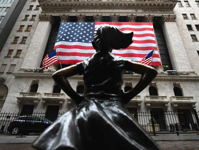 TOPSHOT - The Fearless Girl statue stands in front of the New York Stock Exchange near Wall Street on March 23, 2020 in New York City. - Wall Street fell early March 23, 2020 as Congress wrangled over a massive stimulus package while the Federal Reserve unveiled new emergency programs to boost the economy including with unlimited bond buying. About 45 minutes into trading, the Dow Jones Industrial Average was down 0.6 percent at 19,053.17, and the broad-based S&P 500 also fell 0.6 percent to 2,290.31 after regaining some ground lost just after the open. (Photo by Angela Weiss / AFP)