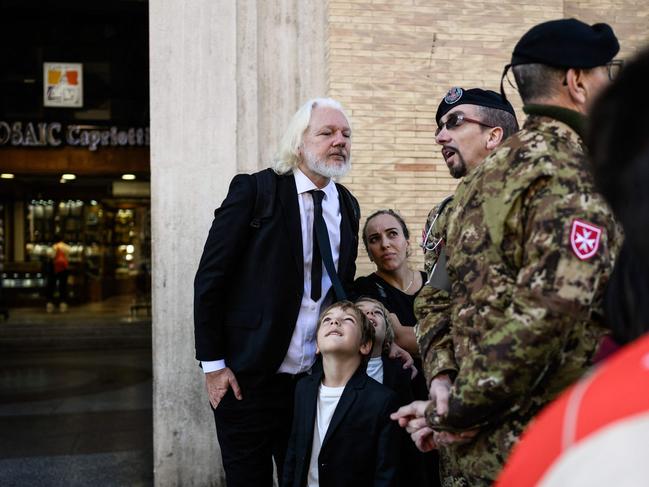 WikiLeaks founder Julian Assange speaks with a member of the military forces in Via della Conciliazione by St Peter’s Square. Picture: AFP