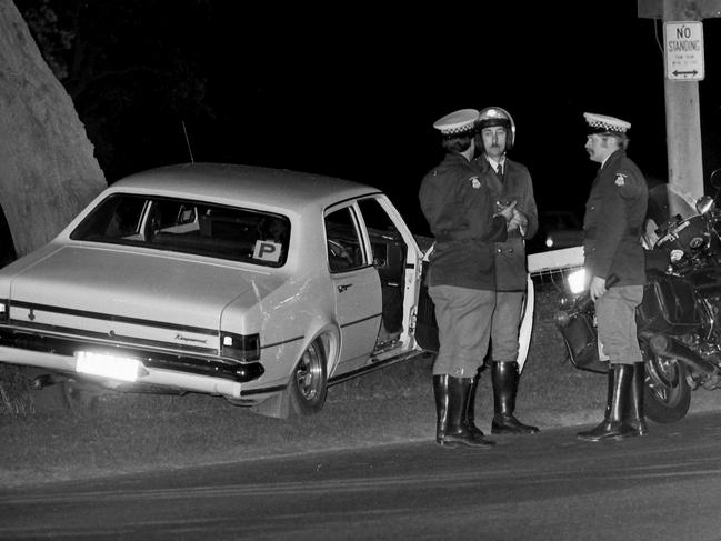 1980. Police stand beside Thomas Cooper’s car after it crashed at Beaumaris Yacht Club carpark. Cowboy killer murder. Neg: 800818