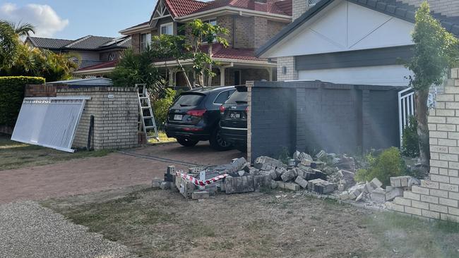 A Runaway Bay home was badly damaged when one of the cars crashed through the front retaining wall.