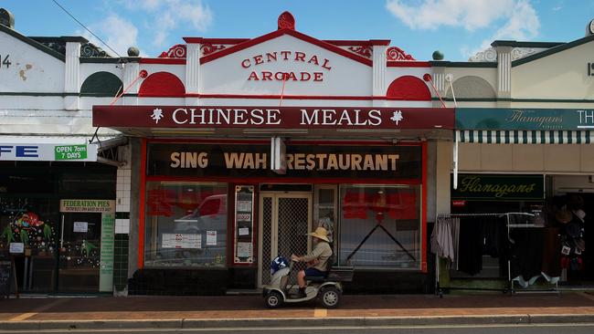 A man proceeds past Sing Wah Chinese restaurant in the main street of Tenterfield.