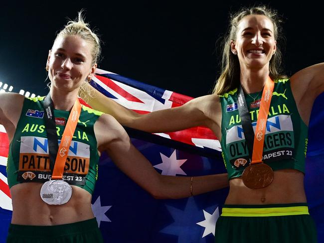 Silver medalist, Australia's Eleanor Patterson (L) and bronze medalist, Australia's Nicola Olyslagers (R) celebrate with their National flags and medals after the women's high jump final during the World Athletics Championships at the National Athletics Centre in Budapest on August 27, 2023. (Photo by Ben Stansall / AFP)