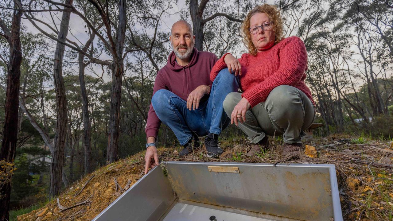 Daniel Katz and partner Jody Roberts standing above the entrance to their bushfire bunker in their Adelaide Hills backyard. Picture: Ben Clark