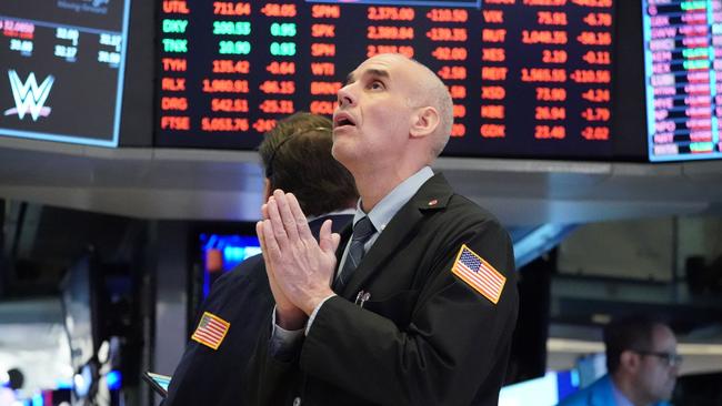 Traders work on the floor at the opening bell of the Dow Industrial Average at the New York Stock Exchange on March 18, 2020 in New York. - Wall Street stocks resumed their downward slide early Wednesday as the economic toll mounts from the rapid near-shutdown of key industrial and services sectors.About 15 minutes into trading, the Dow Jones Industrial Average stood at 20,040.66, down around 1,200 points or 5.6 percent. (Photo by Bryan R. Smith / AFP)