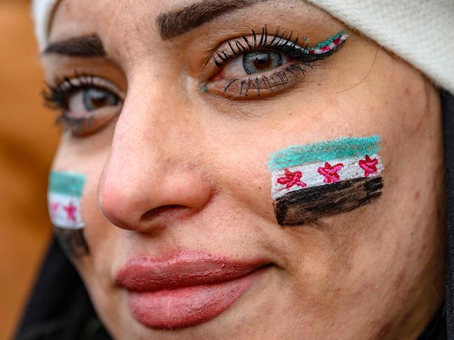 A woman bearing Syrian flags on her cheeks looks on as Syrian residents in Turkey celebrate the end of the Baath rule in Syria after rebel fighters took control of Damascus overnight, at the Fatih Mosque, in Istanbul, on December 8, 2024. Islamist-led rebels declared that they have taken Damascus in a lightning offensive on December 8, sending President Bashar al-Assad fleeing and ending five decades of Baath rule in Syria. (Photo by Yasin AKGUL / AFP)