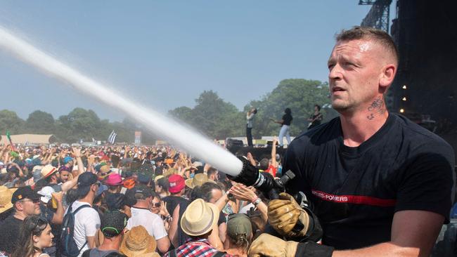 A firefighters sprays music festival-goers in Brittany. Picture: AFP