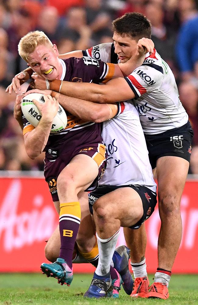 Tom Dearden drags a couple of Roosters behind him. Picture: Bradley Kanaris/Getty Images