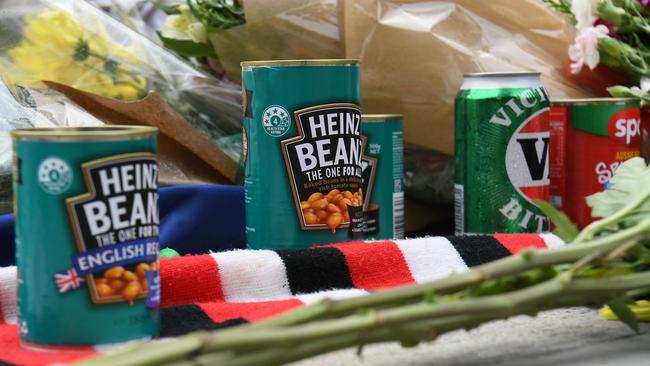 Cans of baked beans and beer at the base of Shane Warne’s statue at the MCG in Melbourne on Sunday. Picture: AFP